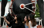 Trois amies font un selfie devant un train à la gare de Phnom Penh, le 5 juin 2021 au Cambodge
