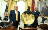 Le patron de la Fédération internationale de football, Gianni Infantino (d), dévoile le trophée de la Coupe du monde des clubs devant le président américain Donald Trump, à la Maison Blanche, le 7 mars 2025 à Washington