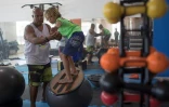 Luiz Augusto de Matos (G), entraîne son élève Miguel Cortinhas, 10 ans, à l'école de surf de Saquamera, le 29 novembre 2017