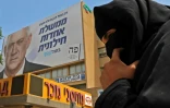 Une femme bédouine près d'une affiche électorale de Benny Gantz, le 15 septembre 2019 à Beer-Sheva (sud d'Israël)