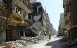 Un soldat syrien marche au milieu des ruines de la ville de Harasta, dans l'enclave rebelle reprise par le régime après une offensive meurtrière, le 26 mars 2018