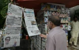 Un Pakistanais lit les titres de la presse dans un kiosque au lendemain des élections.