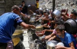 Des déplacés palestiniens viennent chercher à manger dans un point de distribution alimentaire gratuite à Jabalia, dans la bande de Gaza, le 19 mai 2025 