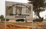 Des soldats passent devant un panneau signalant l'école de Dapchi, Nigeria, le 22 février 2018, trois jours après son attaque par Boko Haram