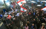 Des libanais lèvent des drapeaux nationaux et dansent pendant que des moutons sont sacrifiés pour célébrer l'élection de Joseph Aoun, originaire de leur village, à la présidence du Liban, dans la ville méridionale d'Aishiyeh, le 9 janvier 2025