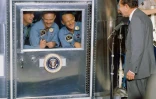 Le président américain Richard Nixon avec les trois astronautes d'Apollo 11, placés en quarantaine à bord du porte-avions USS Hornet, le 24 juillet 1969
