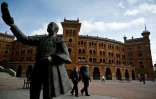 Promeneurs masqués devant les arènes de Madrid, le 2 mai 2020
