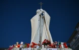 Des bougies et messages au pied de la statue de Jean-Paul II devant l'hôpital Gemelli à Rome où est soigné le pape François, le 4 mars 2025