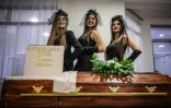 Des mannequins habillées en veuves posent le 2 novembre 2019 devant un gâteau en forme de cercueil à la fête des croque-morts de Pozarevac, en Serbie