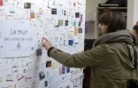 Une femme regarde des cartes de visite sur un mur à l'espace de coworking "Casaco" de Malakoff, le 23 septembre 2015