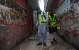 Des employés désinfectent une ruelle dans un quartier de Karachi, le 9 avril 2020 au Pakistan