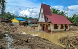 Des villageois se rendent à l'église protestante d'Angkola pour la messe de Noël, dans le village d'Aek Ngadol, le 25 décembre 2025, dans la province de Sumatra touchée par des inondations et glissements de terrain meurtriers, en Indonésie

