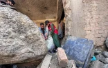 Des habitants fouillent les décombres de boutiques détruites par des crues soudaines à Parun, dans la province du Nouristan, le 21 juillet 2026 en Afghanistan