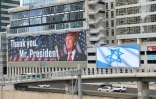 Un panneau d'affichage à Tel-Aviv montre une photo du président américain Donald Trump avec l'inscription "Merci, président Trump" et un autre arbore le drapeau israélien, après l'accord sur Gaza, le 9 octobre 2025