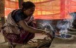 Somari Negi, veuve de Rameshwar Negi, tué l'année dernière par les paramilitaires qui le soupçonnaient d'être un rebelle maoïste, prépare un repas chez elle à Marda, dans le district de Bastar de l'Etat de Chhattisgarh, le 14 mars 2025 dans le centre de l'Inde
