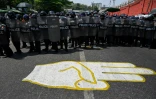 La police anti-émeutes déployées dans une rue de Rangoun où des protestataires ont dessiné le salut à trois doigts, emblème de la contestation, le 25 février 2021