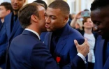 Le président Emmanuel Macron embrasse Kylian Mbappé en lui remettant la Légion d'honneur au Palais de l'Elysée à Paris le 4 juillet 2019 