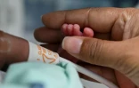 Diana Angola, atteinte par le coronavirus, caresse le pied de son fils Jefferson Ă la clinique de Versalles, le 23 juin 2020 Ă Cali, en Colombie