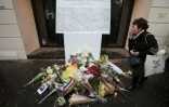 Une plaque commémorative et des fleurs devant l'entrée de la salle de concert le Bataclan à Paris, le 13 novembre 2016, un an après l'attaque qui a fait 90 morts