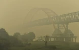 La silhouette du pont de la ville de Palangkaraya dans l'épaisse fumée jaune provoquée par les incendies de forêts, le 27 octobre 2015 en Indonésie
