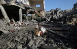 Un Palestinien récupère quelques biens  dans une maison ciblée par une frappe israélienne dans le camp de réfugiés de Nousseirat, dans le centre de la bande de Gaza, le 24 mai 2025
