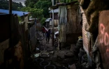 Un habitant transporte des matériaux dans le bidonville "Talus 2", dans le nord de Mayotte, promis à une démolition imminente, le 21 mai 2023