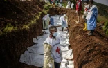 Un membre de la Croix-Rouge congolaise devant une fosse commune dans un cimetière de Bukavu, dans l'est de la RDC, le 20 février 2025 
