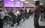 Des membres de la sécurité surveillent les accusés assis dans un box en verre, lors du procès des attentats de Bruxelles, le 25 juillet 2023 à Bruxelles