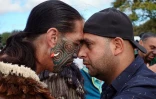 Un musulman (à droite) et un non-musulman pratiquent le "hongri", salutation traditionnelle maori, pendant la prière du vendredi devant la mosquée al-Nour de Christchurch, le 22 mars 2019
