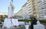 Une none prie devant la statue de Jean Paul II, sur le parvis de l'hôpital Gemelli de Rome, dans lequel est hospitalisé le pape François, le 22 février 2025