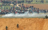Des manifestants palestiniens et des soldats israéliens se font face à la frontière de la bande de Gaza, le 30 mars 2018