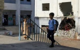 Des jeunes Yéménites à l'entrée d'une école endommagée au Yémen en guerre à l'occasion de la rentrée scolaire  le 16 septembre 2018