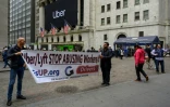Deux chauffeurs d'Uber manifestent devant le bâtiment de la Bourse de New York à Manhattan.