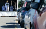 Des automobilistes garés sur un parking assistent à une messe en plein air célébrée par Mgr François Touvet, l'évêque de Châlons-en-Champagne, le 17 mai 2020