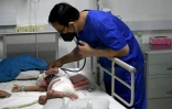 Un médecin examine un enfant à l'hôpital d'Angkor, le 6 juillet 2022 à Siem Reap, au Cambodge