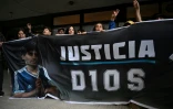 Des fans tiennent un drapeau à l'image du défunt Diego Maradona devant le tribunal de San Isidro, avant le procès concernant la mort de la légende argentine du football à San Isidro, dans la province de Buenos Aires, Argentine, le 11 mars 2025