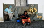 Un ouvrier se repose devant l'une des peintures murales réalisées par l'artiste française Léo Arti, à 25 de agosto, village du centre de l'Urugay, le 12 juin 2017