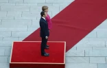 La chancelière allemande Angela Merkel (d) et le président français Emmanuel Macron, écoutant les hymnes nationaux lors d'une rencontre à Berlin le 15 mai 2017