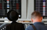 Des passagers devant un tableau d'affichage de l'aéroport Ben Gourion de Tel-Aviv, le 6 août 2024