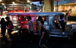 Des passagers attendent des jeepneys, taxis collectifs sur des châssis de jeep, dans une rue de Manille, le 15 janvier 2024