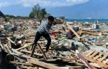 Un survivant du séisme meurtrier qui a frappé Palu sur l'île des Célèbes en Indonésie tente de récupérer des objets dans les décombres, le 1er octobre 2018