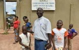 L'abbé Germain Coulibaly Kalari avec des enfants à l'entrée du "Centre d'accueil et de transit Sainte Geneviève" le 4 septembre 2016 à Katiola en Côte d'Ivoire