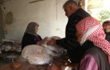 Des Syriens font la queue pour acheter du pain dans une boulangerie de la ville de Qousseir, dans la province centrale de Homs en Syrie, le 14 décembre 2024