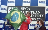Ayrton Senna, alors pilote chez McLaren, brandit le drapeau brésilien sur le podium du Grand Prix d'Europe, le 11 avril 1993 à Donington (Royaume-Uni)