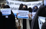 Une pancarte "Les femmes qui ont quitté l'Afghanistan ne peuvent pas nous représenter" brandie par une Afghane en niqab noir lors d'un rassemblement pro-talibans devant l'université Shaheed Rabbani, le 11 septembre 2021 à Kaboul