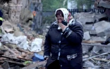 Photo prise et diffusée par le service de presse des services d'urgence de l'État ukrainien, le 25 mai 2025, montrant une femme en larmes à côté de sa maison endommagée par une frappe russe dans la région Khmelnytskyi, dans l'ouest du pays