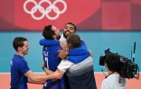 Les Français Benjamin Toniutti, Kevin Tillie et Earvin Ngapeth, de gauche à droite, partagent leur joie avec le sélectionneur Laurent Tillie après leur victoire en finale des Jeux olympiques le 7 août 2021 à Tokyo