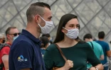 Des touristes près de la pyramide du Louvre à Paris, le 15 août 2020, où le port du masque est déjà obligatoire