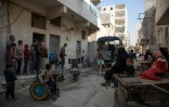 Des habitants reçoivent une aide alimentaire de la fondation Al-Sham dans le quartier rebelle d'al-Marjah, le 15 novembre 2016 à Alep, en Syrie