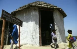 Des enfants sortent d'une école conçue pour résister aux inondation au village de Pono Colony, le 8 avril 2023 au Pakistan